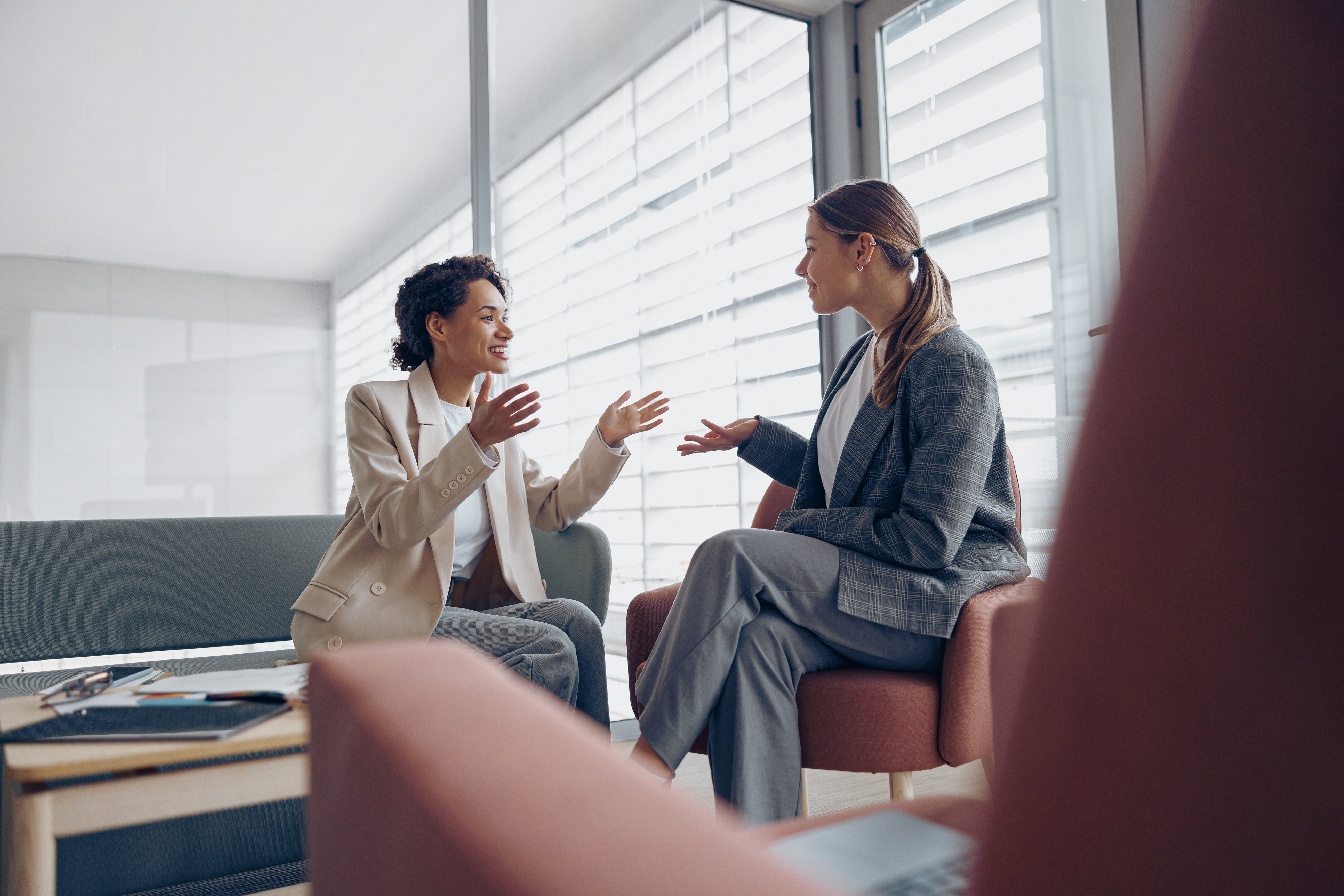 Happy diverse women office workers is distracted from work and talking in office during break